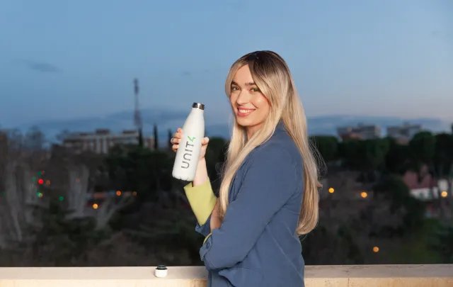 Person holding unit4 flask and smiling to the camera