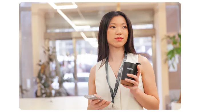 Woman with cup of coffee and phone in an office environment