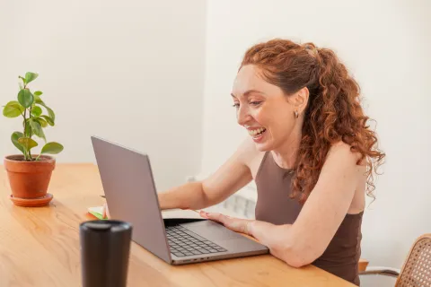 Woman smiling to computer screen