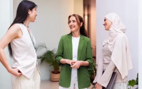 Three colleagues having a conversation in an office